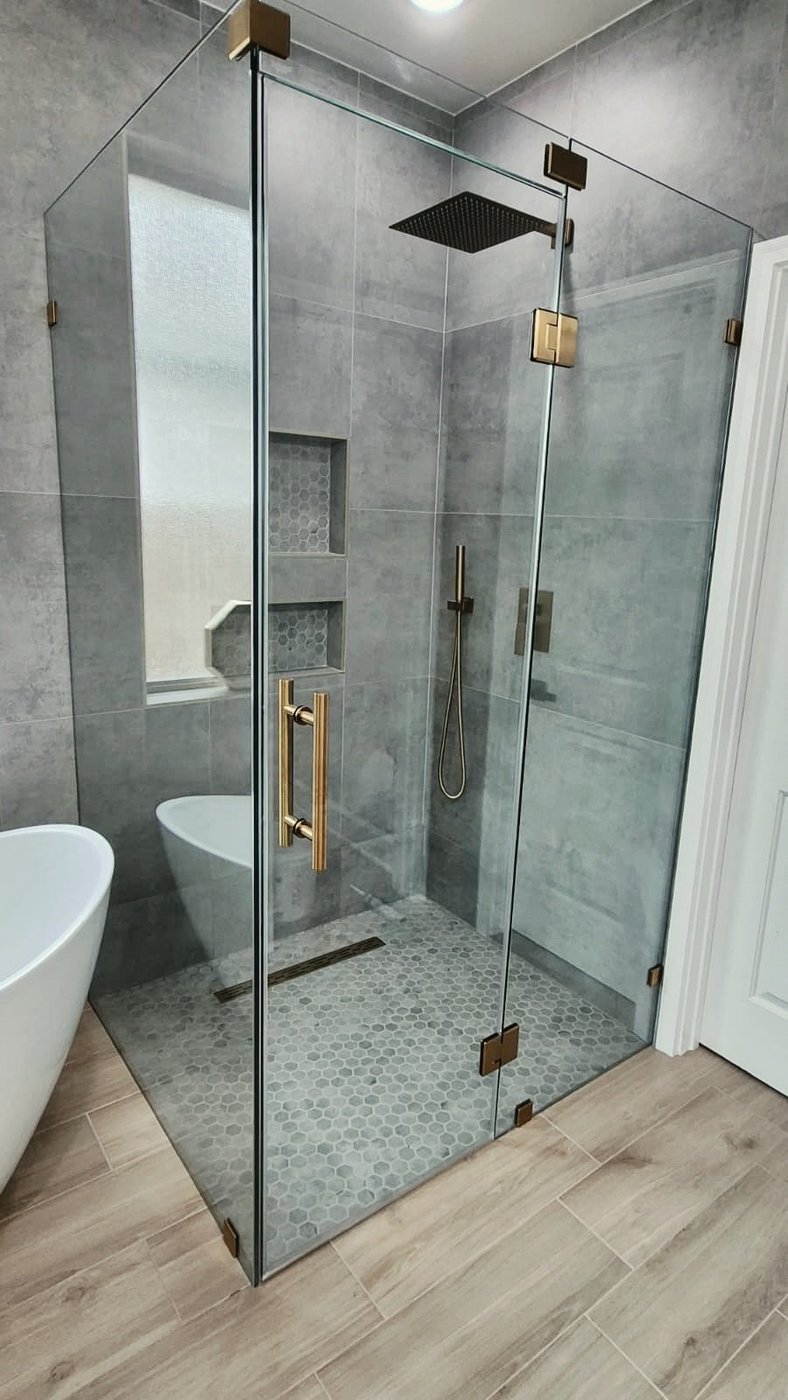 Trabajo de Glas Plus: ángulo 90° con herraje dorado en un baño de azulejo gris