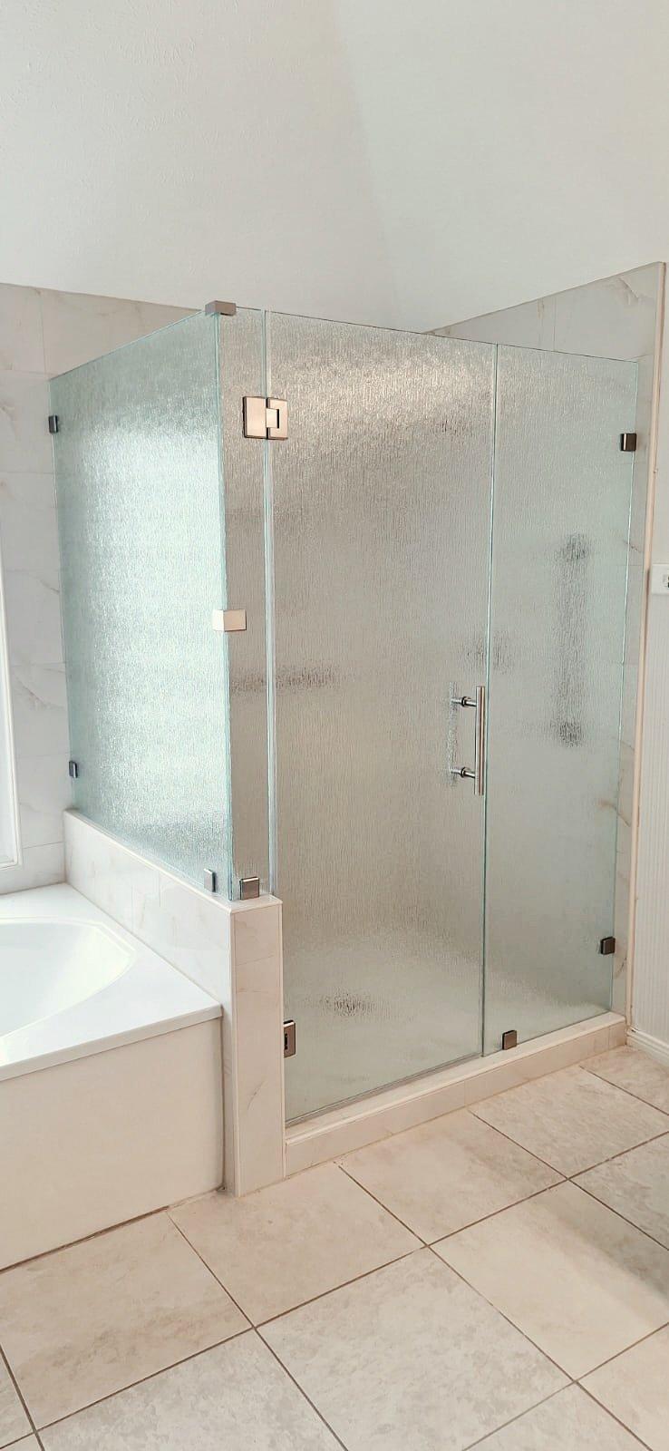 Trabajo de Glas Plus: shower en ángulo 90° con vidrio Rain (textura de lluvia) sobre un muro, junto a la tina