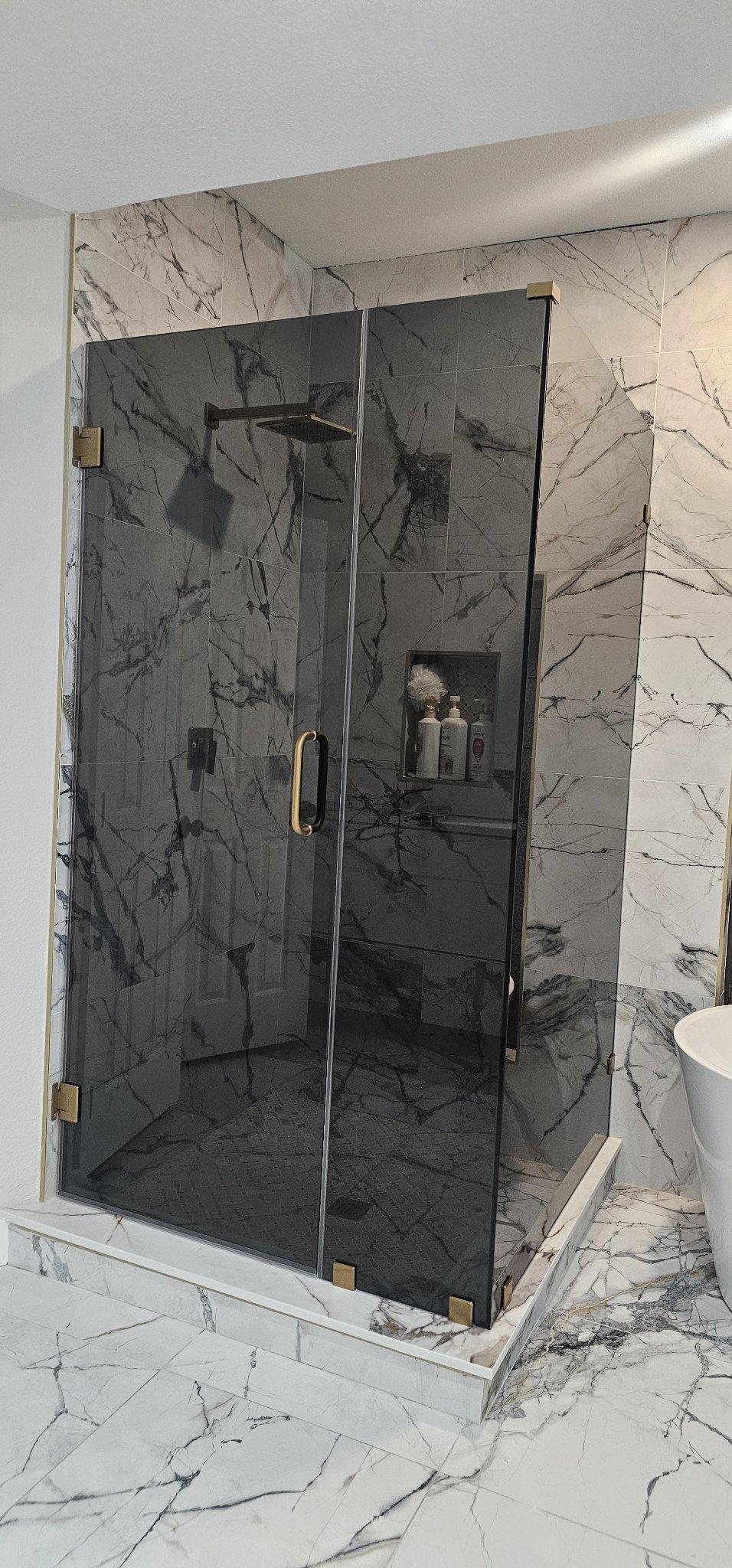 Trabajo de Glas Plus: shower en ángulo 90° con vidrio Grey (gris ahumado) y herraje dorado