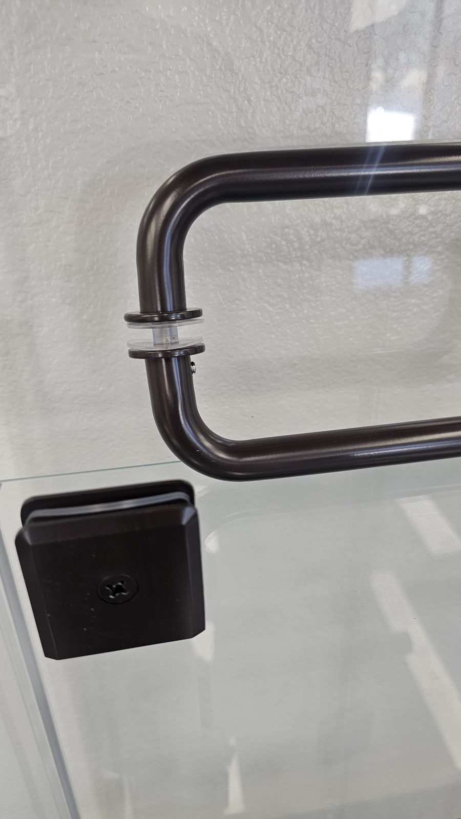Manija y clip en bronce oscuro de Glas Plus montados sobre un vidrio de exhibición
