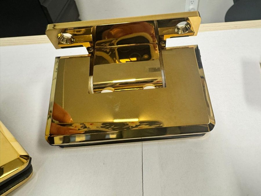 Bisagra en dorado pulido de Glas Plus sobre una mesa blanca