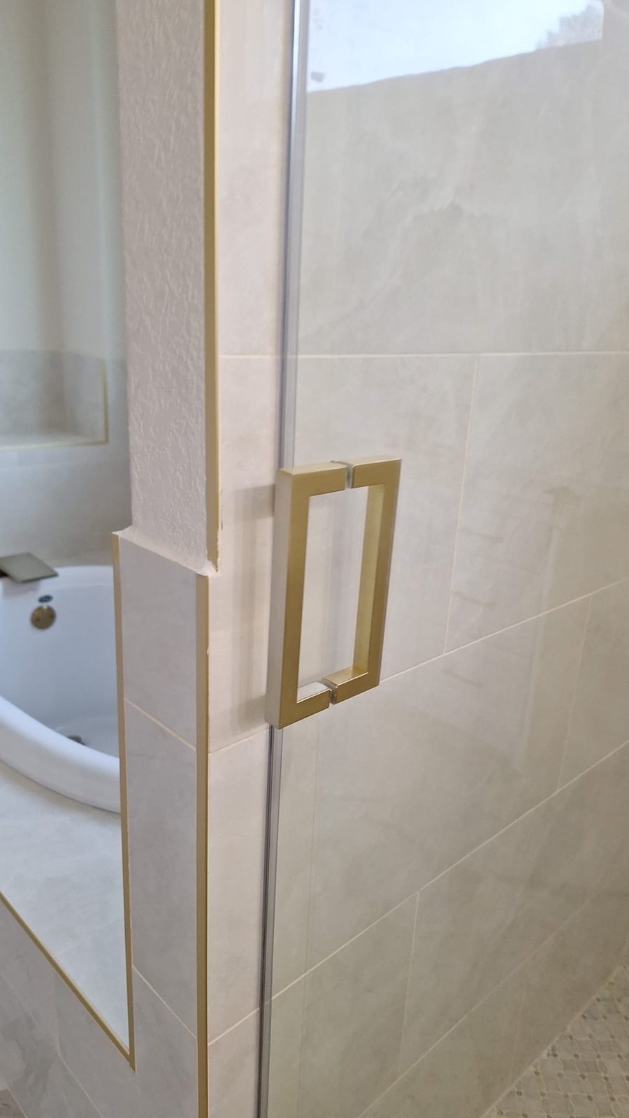 Manija cuadrada brush gold de Glas Plus instalada en una puerta de vidrio de shower
