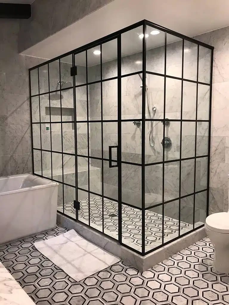 Trabajo de Glas Plus: estilo industrial con rejilla negra completa en un shower grande junto a una tina, con piso hexagonal