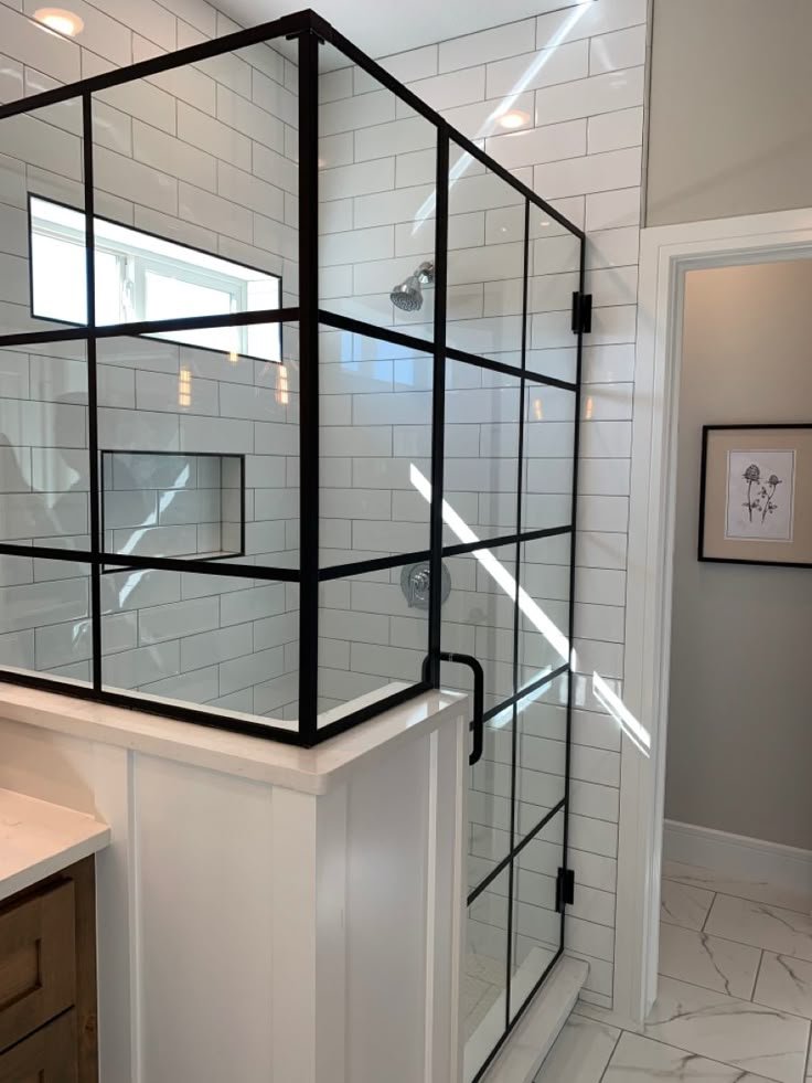 Trabajo de Glas Plus: estilo industrial con rejilla negra y vidrio montado sobre un muro o murete, en shower de azulejo subway blanco