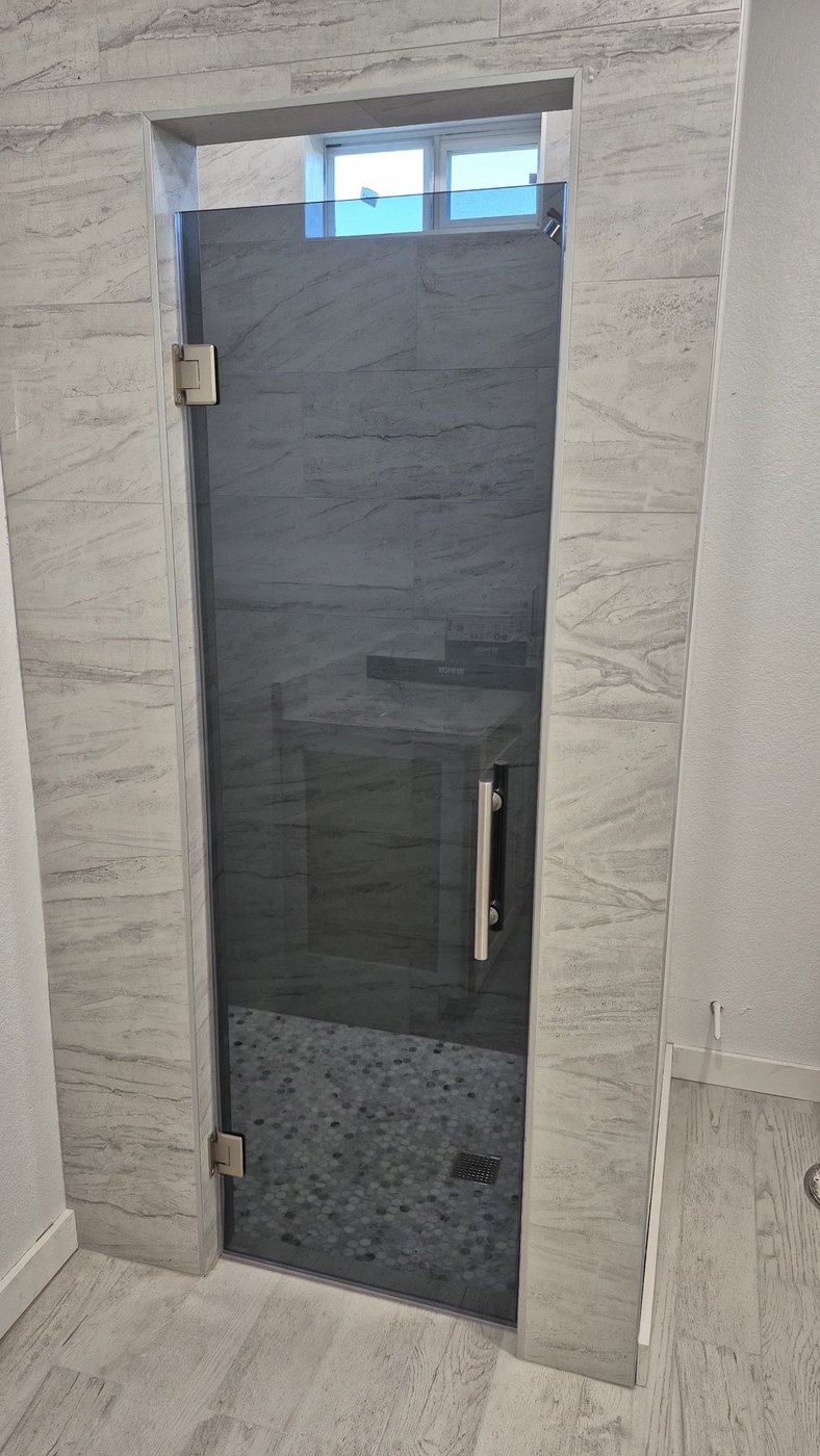 Single door con vidrio Grey (gris ahumado) y herraje brush nickel instalada por Glas Plus