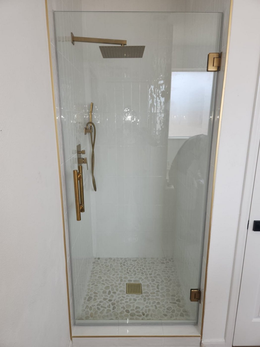 Single door con herraje brush gold instalada por Glas Plus en un shower de azulejo blanco