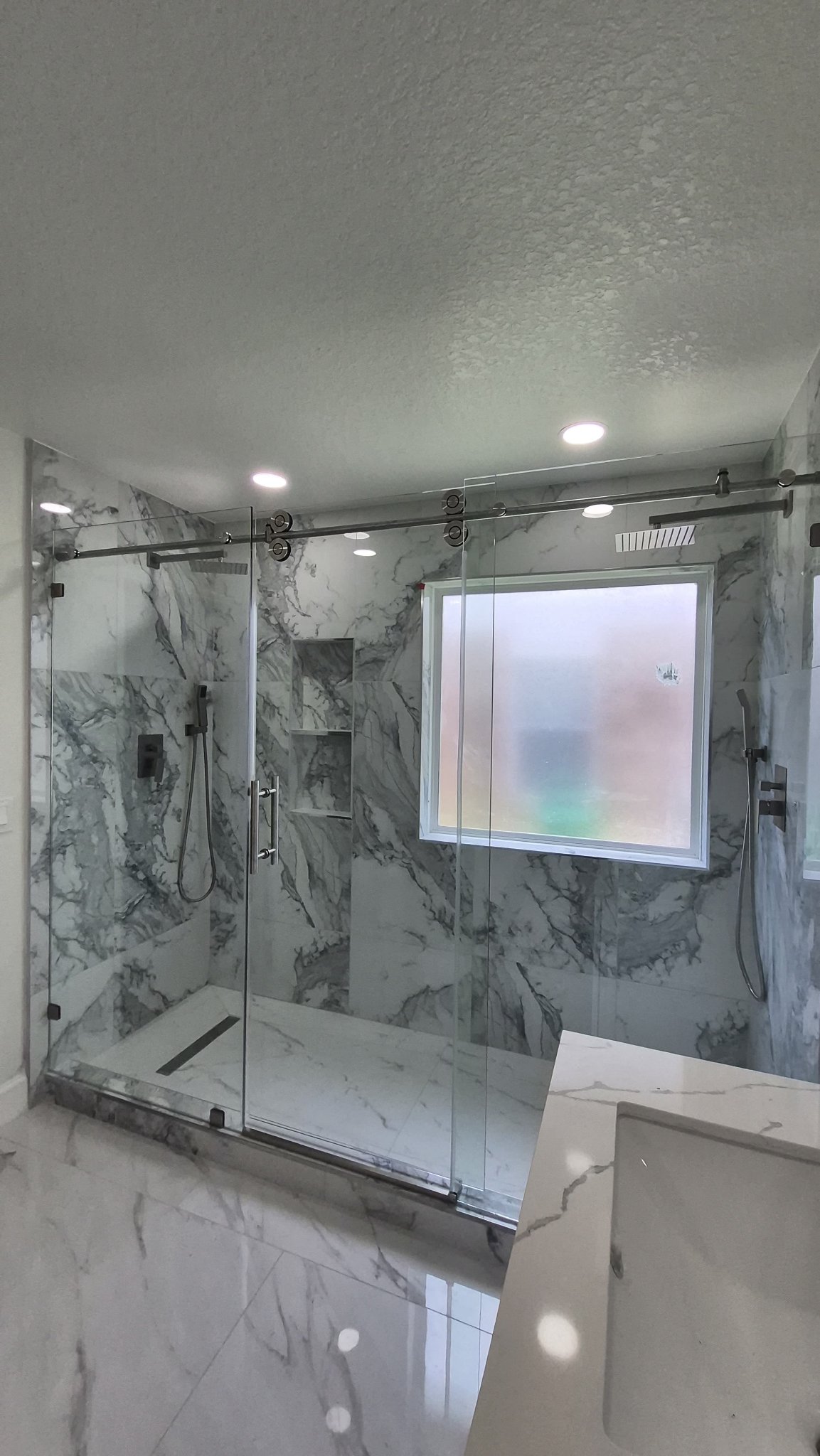 Sliding ancha de vidrio clear con riel cromado en shower amplio de mármol con ventana interior