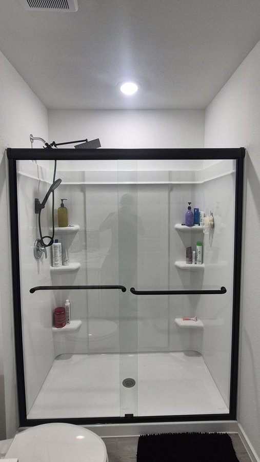 Sliding doble puerta con marco completo negro en shower gris con nicho
