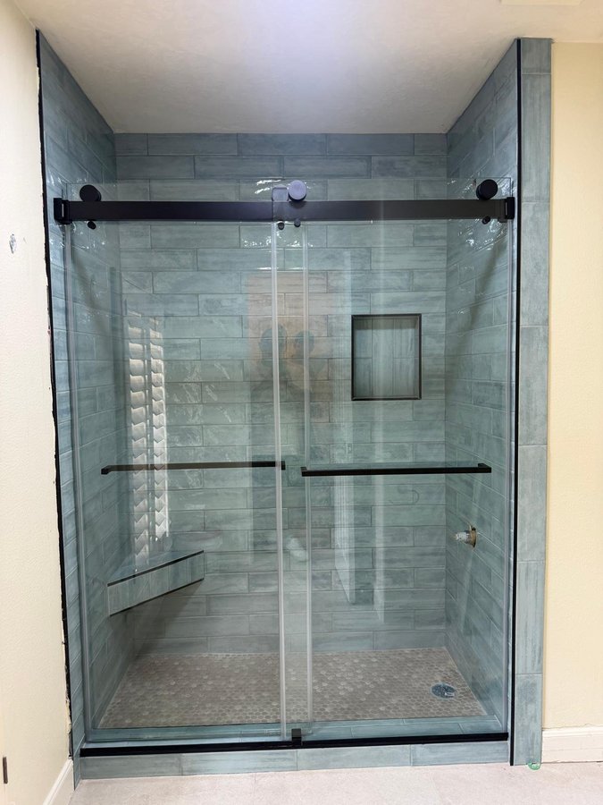 Sliding doble puerta con riel negro en shower de azulejo mármol con nicho