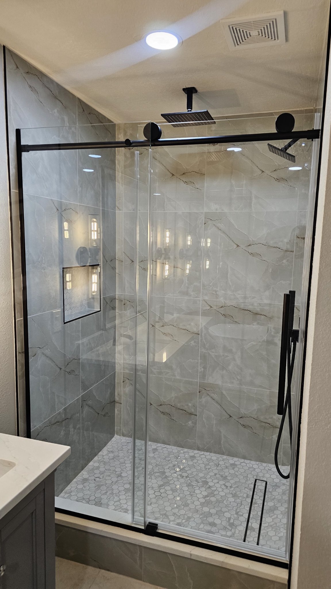 Foto de referencia del sliding cierre suave (soft-close) de Glas Plus: una puerta corrediza con cierre suave y panel fijo de vidrio clear, con herraje negro