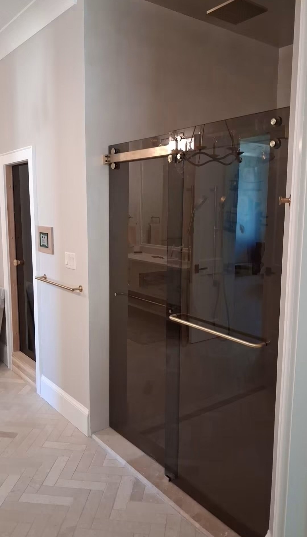 Sliding doble puerta con vidrio Bronze (tono bronce) y riel de brush nickel en la entrada de un shower