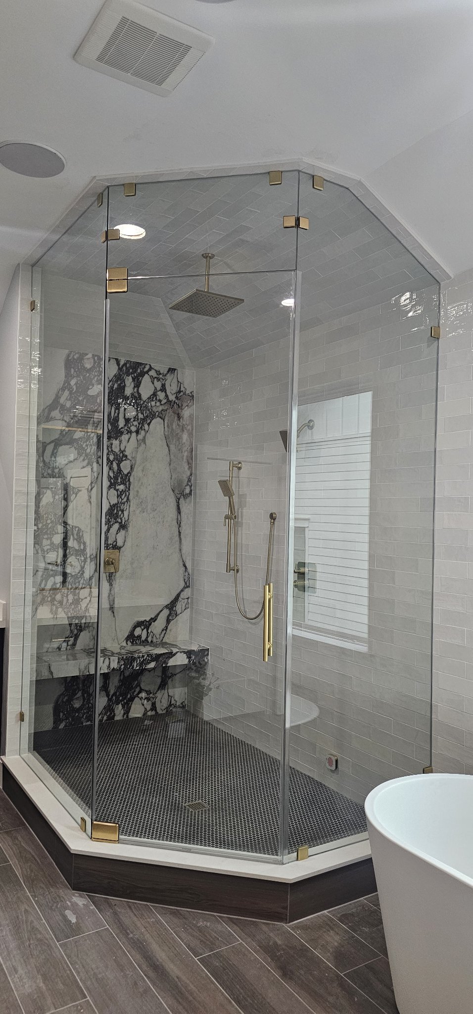 Foto de referencia del steam shower door: shower de vidrio que llega hasta el techo, tipo sauna, con herraje dorado